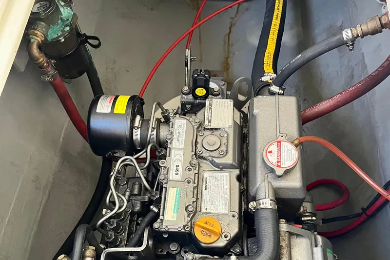Slide: The Image of Engine compartment of a 2008 Seawind 1160 catamaran, showcasing mechanical components and hoses. - 18