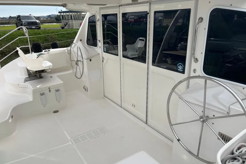 Slide: The Image of 2008 Seawind 1160 catamaran cockpit with dual steering wheels and seating area. - 21