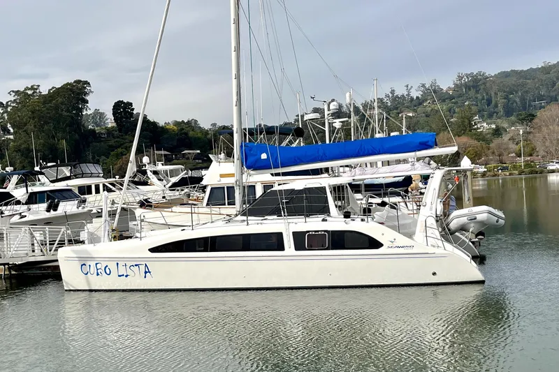 Slide: The Image of 2008 Seawind 1160 catamaran docked in a marina with scenic background. - 22