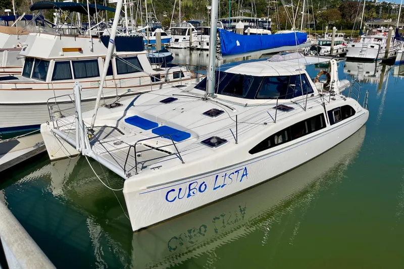 Slide: The Image of 2008 Seawind 1160 catamaran docked in a marina, surrounded by other boats. - 23