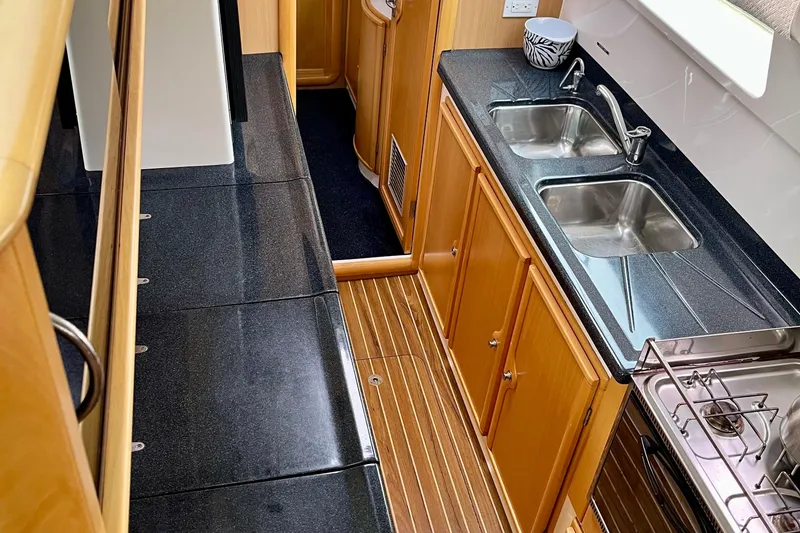 Slide: The Image of Interior of 2008 Seawind 1160 yacht kitchen with dual sinks and wooden cabinetry. - 9