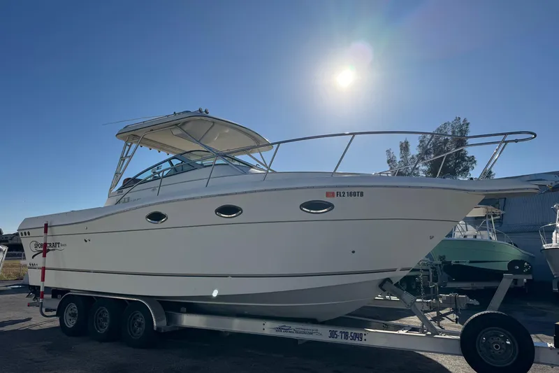 The Image of 2002 Sport-Craft 3150 Sportfish boat on trailer under bright sun. - 0