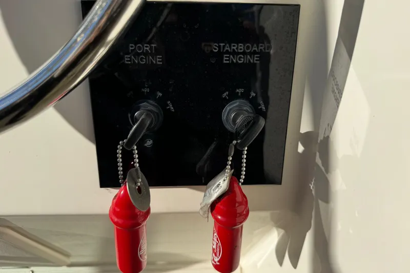 Slide: The Image of 2002 Sport-Craft 3150 Sportfish engine ignition panel with keys and red safety lanyards. - 11