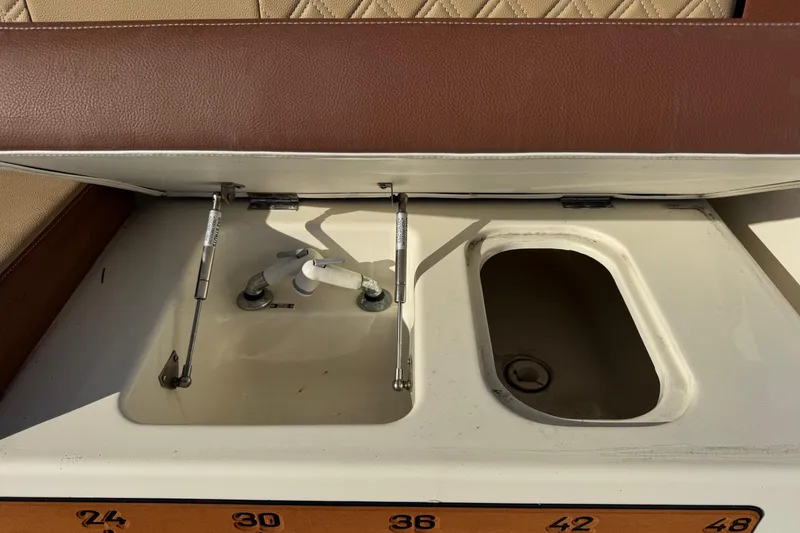 Slide: The Image of 2002 Sport-Craft 3150 Sportfish boat storage compartment with open lid and visible hinges. - 20