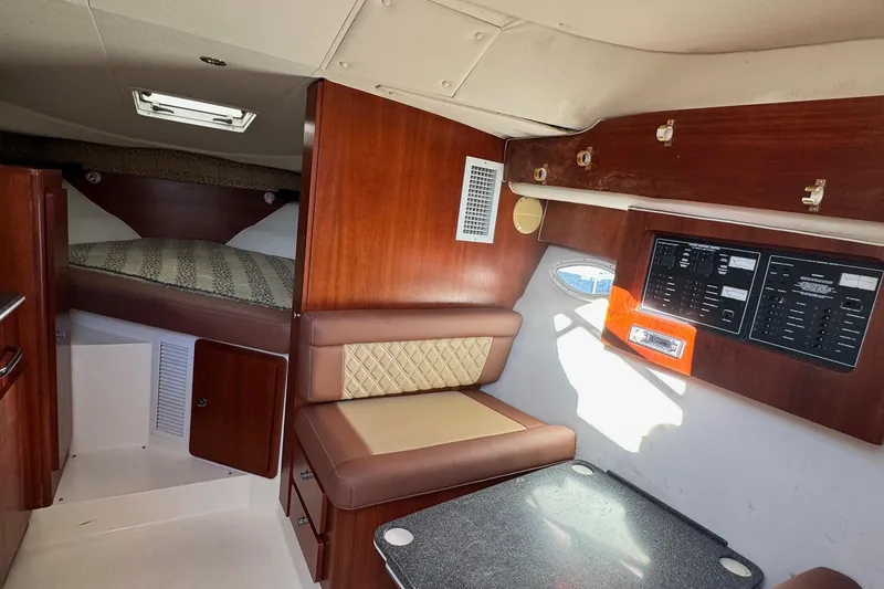 Slide: The Image of 2002 Sport-Craft 3150 Sportfish cabin interior with seating, bed, and control panel. - 26
