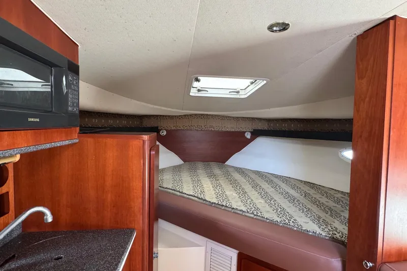 Slide: The Image of 2002 Sport-Craft 3150 Sportfish cabin interior with bed, microwave, and sink. - 29