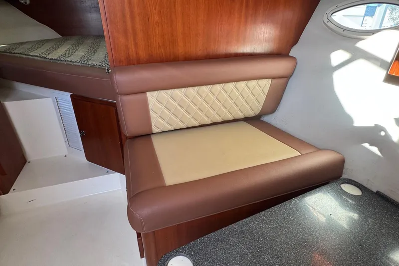 Slide: The Image of 2002 Sport-Craft 3150 Sportfish cabin interior with cushioned seating and wood paneling. - 37