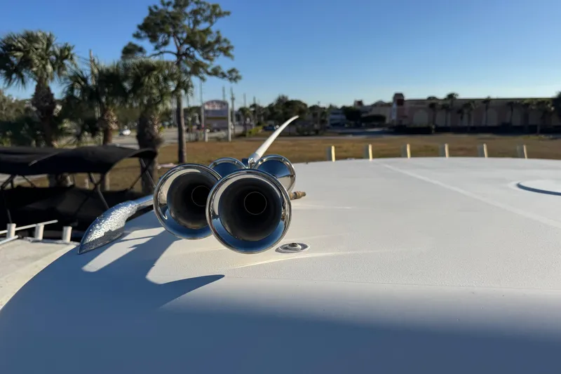 Slide: The Image of 2002 Sport-Craft 3150 Sportfish boat deck with chrome horns, sunny day, palm trees in background. - 45