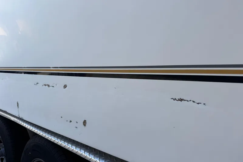 Slide: The Image of 2002 Sport-Craft 3150 Sportfish boat with visible hull scratches and wear. - 64