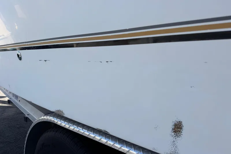 Slide: The Image of 2002 Sport-Craft 3150 Sportfish boat with visible hull scratches and minor rust spots. - 65