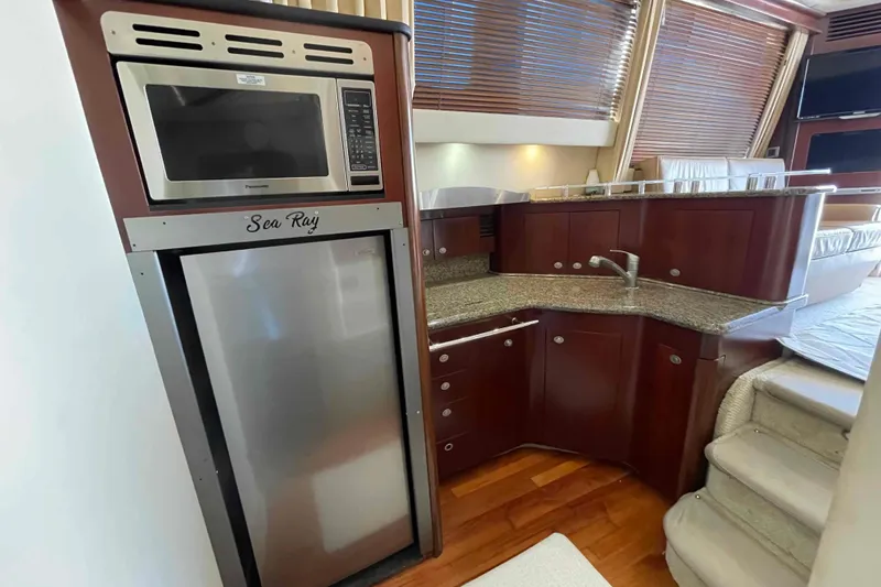 Slide: The Image of Luxurious 2005 Sea Ray 420 Sedan Bridge yacht kitchen with modern appliances and wood cabinetry. - 10