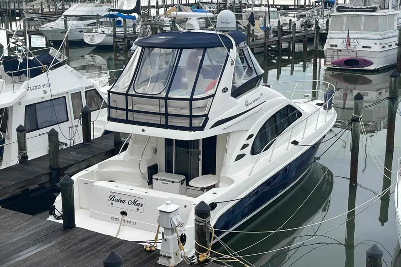 Slide: The Image of 2005 Sea Ray 420 Sedan Bridge yacht docked at marina, surrounded by other boats. - 111