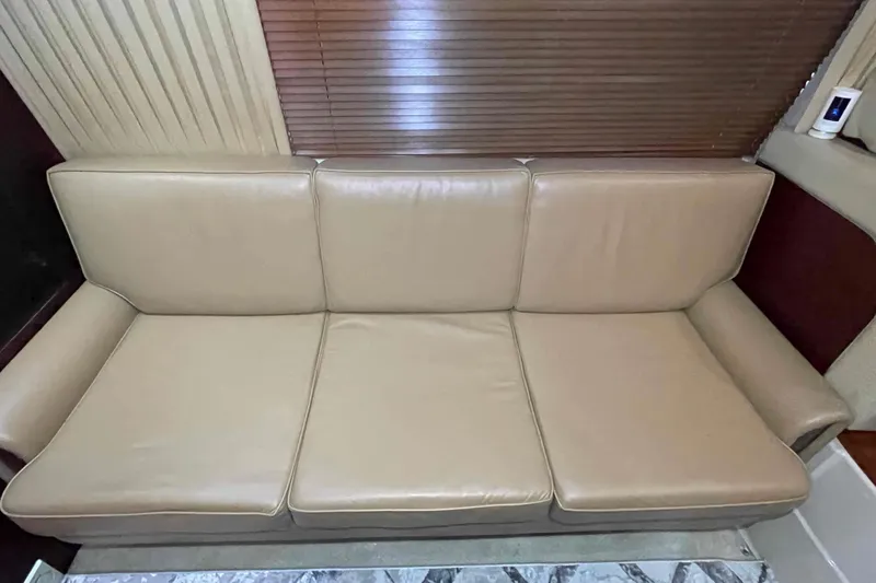 Slide: The Image of Luxurious interior of 2005 Sea Ray 420 Sedan Bridge with beige leather sofa and wooden table. - 16