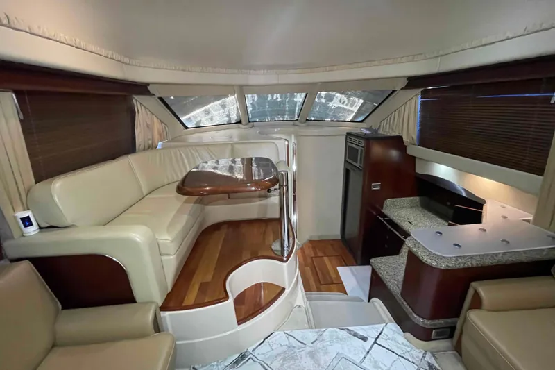 Slide: The Image of Luxurious interior of 2005 Sea Ray 420 Sedan Bridge yacht with leather seating and wooden table. - 22