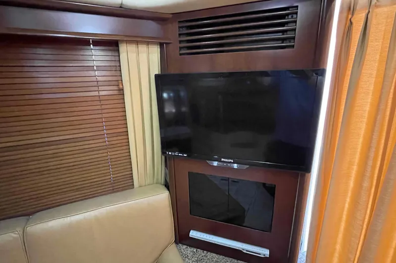 Slide: The Image of 2005 Sea Ray 420 Sedan Bridge cabin with twin beds and warm lighting. - 29