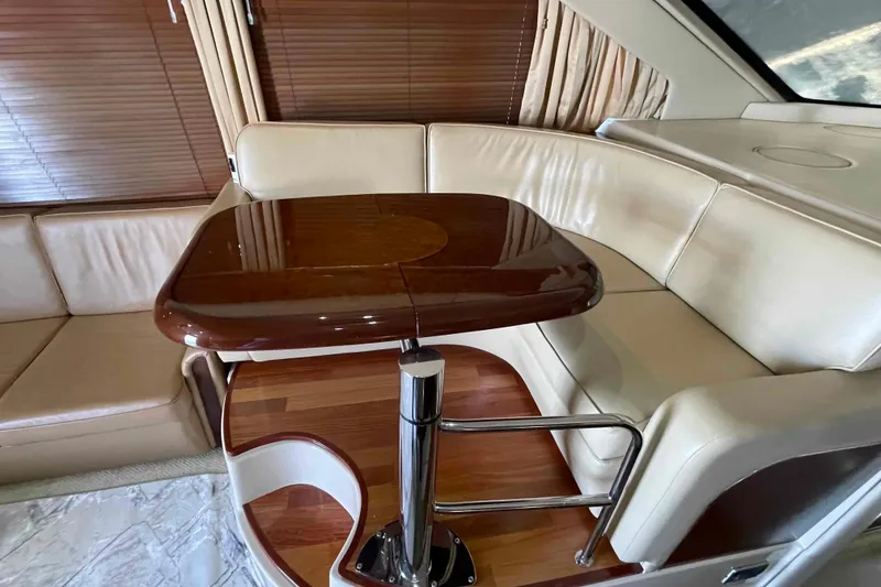 Slide: The Image of Luxurious interior of 2005 Sea Ray 420 Sedan Bridge with elegant seating and wooden table. - 7