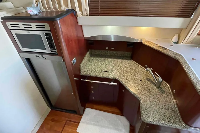 Slide: The Image of 2005 Sea Ray 420 Sedan Bridge kitchen with granite countertops and built-in appliances. - 9