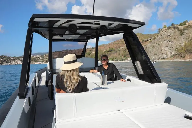 Slide: The Image of 2026 Ranieri Cayman 45.0 Executive boat with passengers enjoying a scenic coastal view. - 19