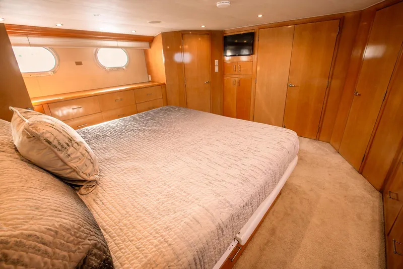 Slide: The Image of Luxurious bedroom interior of 2001 Hatteras 75 Cockpit Motor Yacht with wood paneling and cozy bedding. - 19