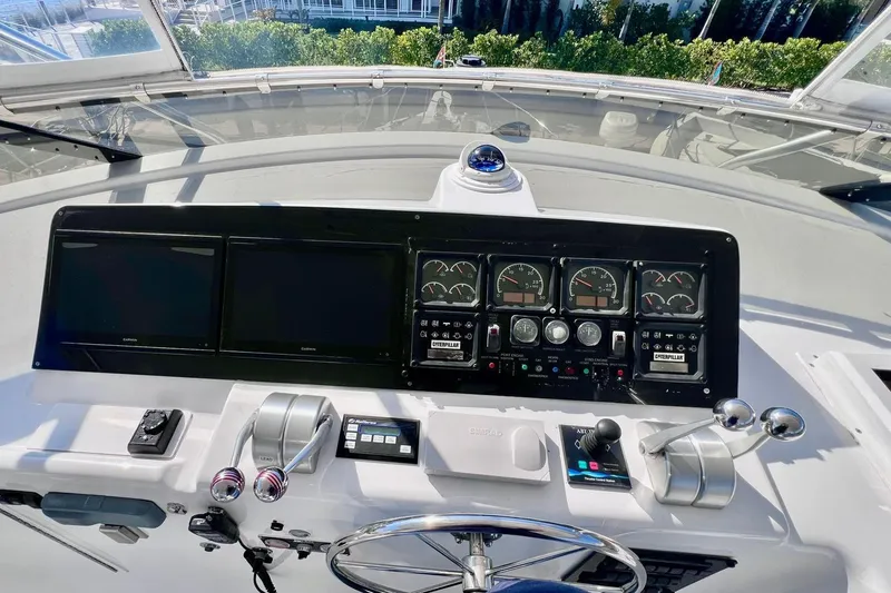 Slide: The Image of Cockpit controls of 2001 Hatteras 75 Cockpit Motor Yacht with navigation screens and gauges. - 28