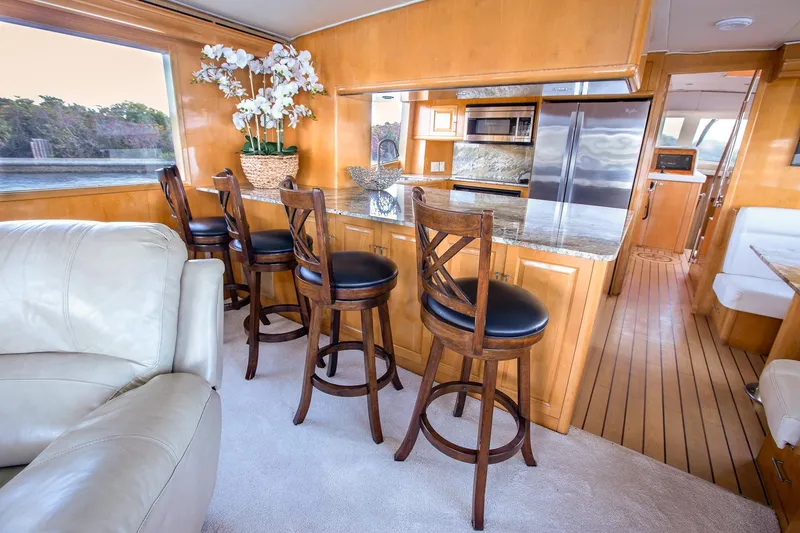Slide: The Image of Luxurious interior of 2001 Hatteras 75 Cockpit Motor Yacht with elegant bar seating. - 9