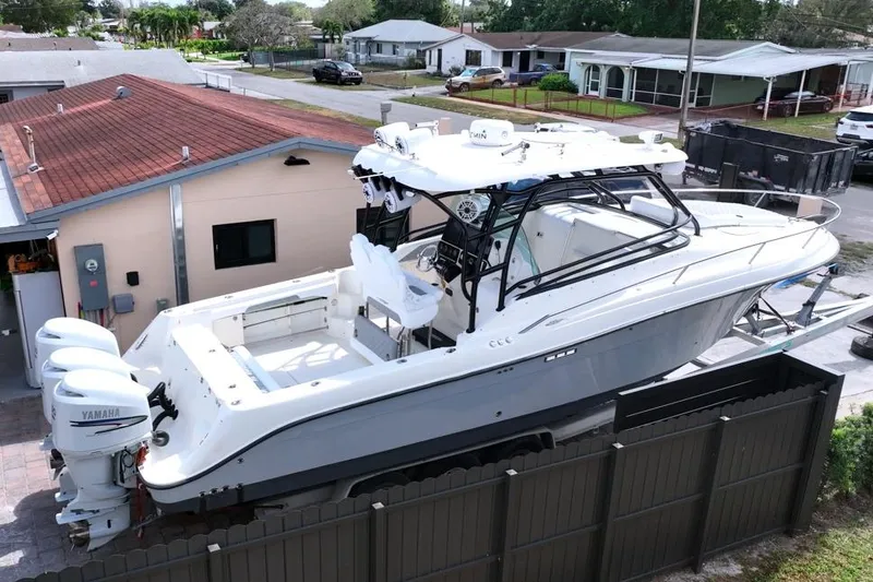 The Image of 2006 Hydra-Sports Vector 3300 VX boat with Yamaha engines, parked near residential area. - 0