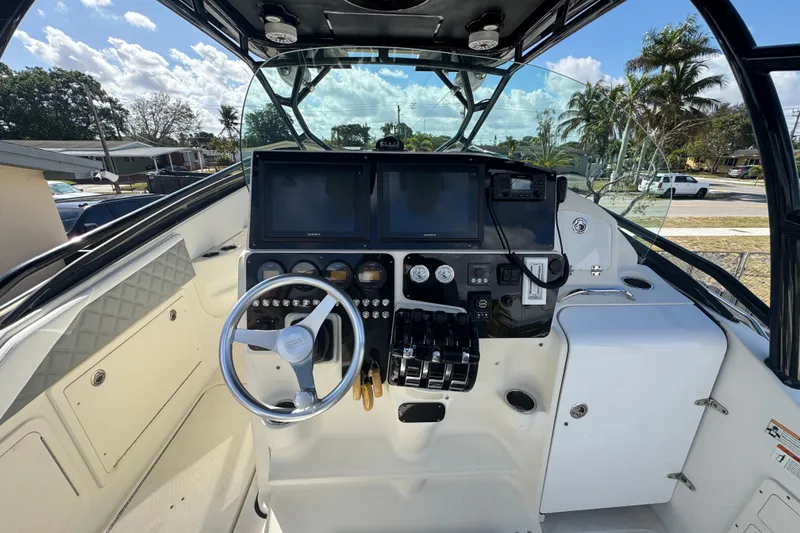 Slide: The Image of 2006 Hydra-Sports Vector 3300 VX boat cockpit with steering wheel and navigation controls. - 13