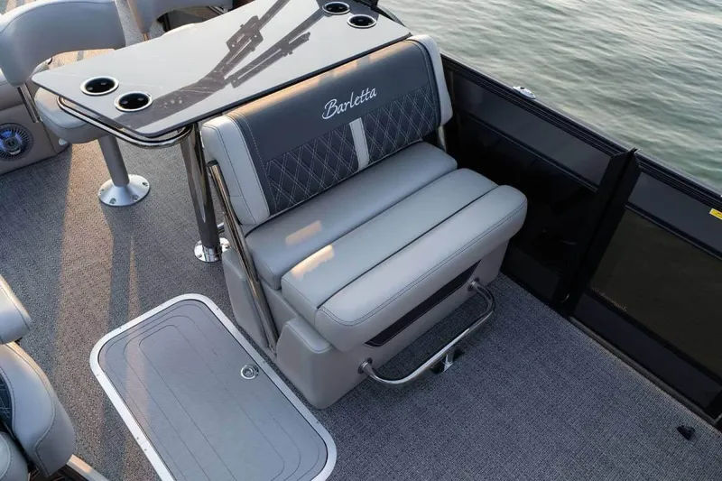 Slide: The Image of Manufacturer Provided Image: 2026 Barletta Lusso 25UE boat interior with luxury seating and table, overlooking water. - 3