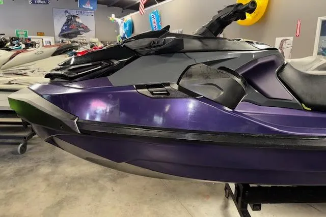 Slide: The Image of 2021 Sea-Doo RXT-X 300 jet ski in showroom, side view, purple and black design. - 3