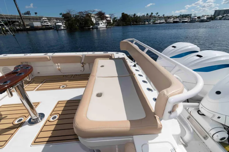 Slide: The Image of 2021 HCB 53 Sueños boat interior with seating and outboard motors, docked by the water. - 18