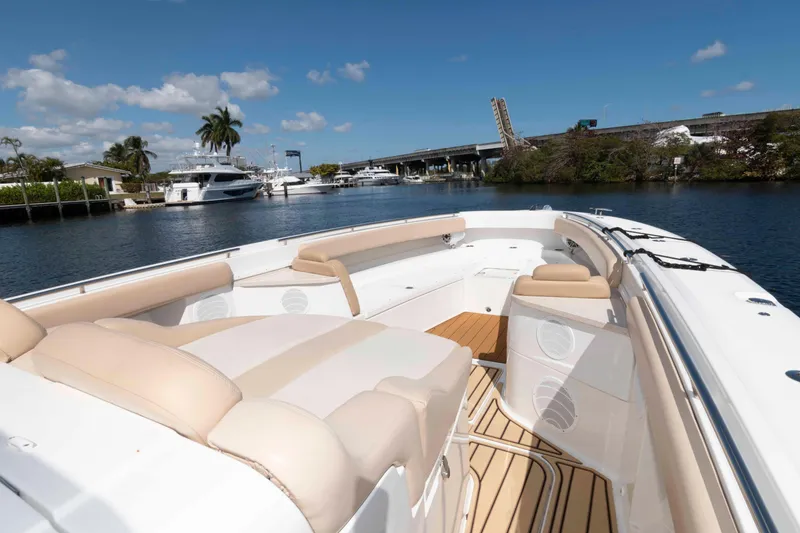 Slide: The Image of 2021 HCB 53 Sueños boat with spacious deck, docked near a bridge and palm trees. - 19