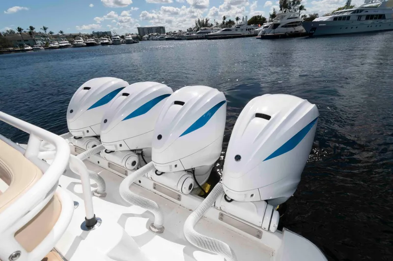 Slide: The Image of Four powerful outboard motors on a 2021 HCB 53 Sueños boat, docked in a marina. - 24