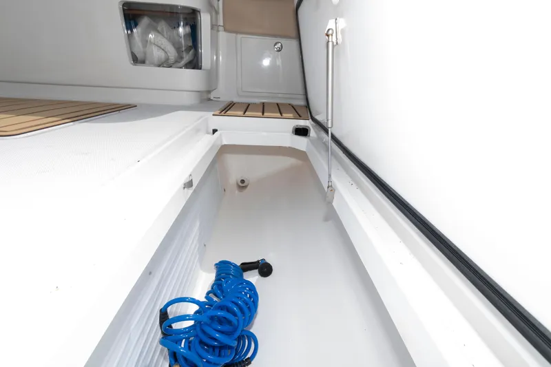 Slide: The Image of Interior view of 2021 HCB 53 Sueños boat storage compartment with blue hose. - 33