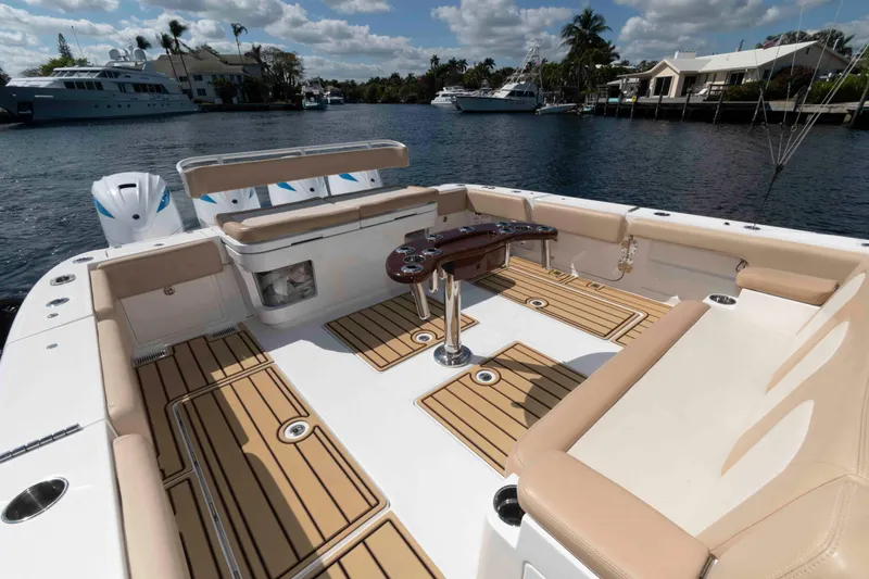 Slide: The Image of 2021 HCB 53 Sueños boat deck with seating, table, and scenic waterfront view. - 6