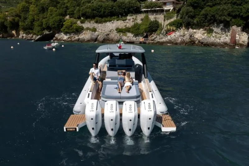 Slide: The Image of 2026 Ranieri CAYMAN 50.0 HARD TOP yacht cruising with passengers, featuring four powerful outboard engines. - 28