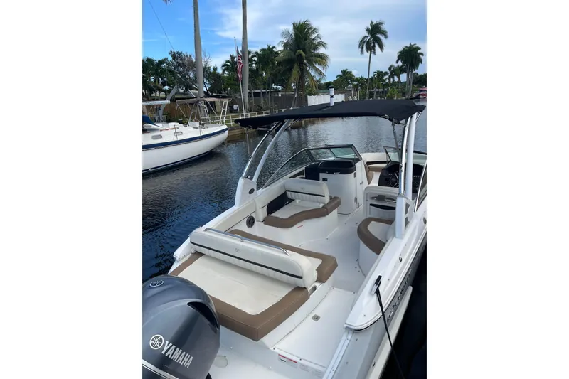 Slide: The Image of 2021 Cobalt 25SC boat with Yamaha engine, docked near palm trees and waterway. - 12