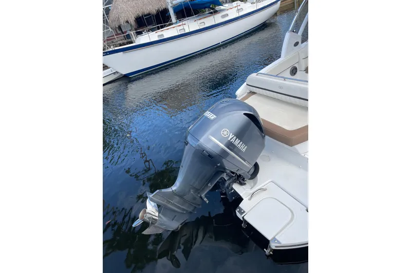 Slide: The Image of 2021 Cobalt 25SC boat with Yamaha outboard motor docked on calm water. - 13