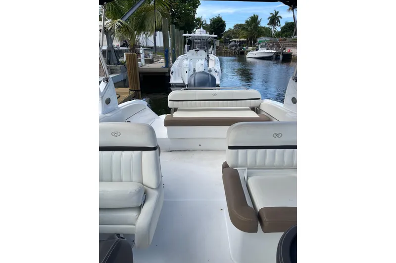 Slide: The Image of 2021 Cobalt 25SC boat interior with white and brown seating, docked by a canal. - 6