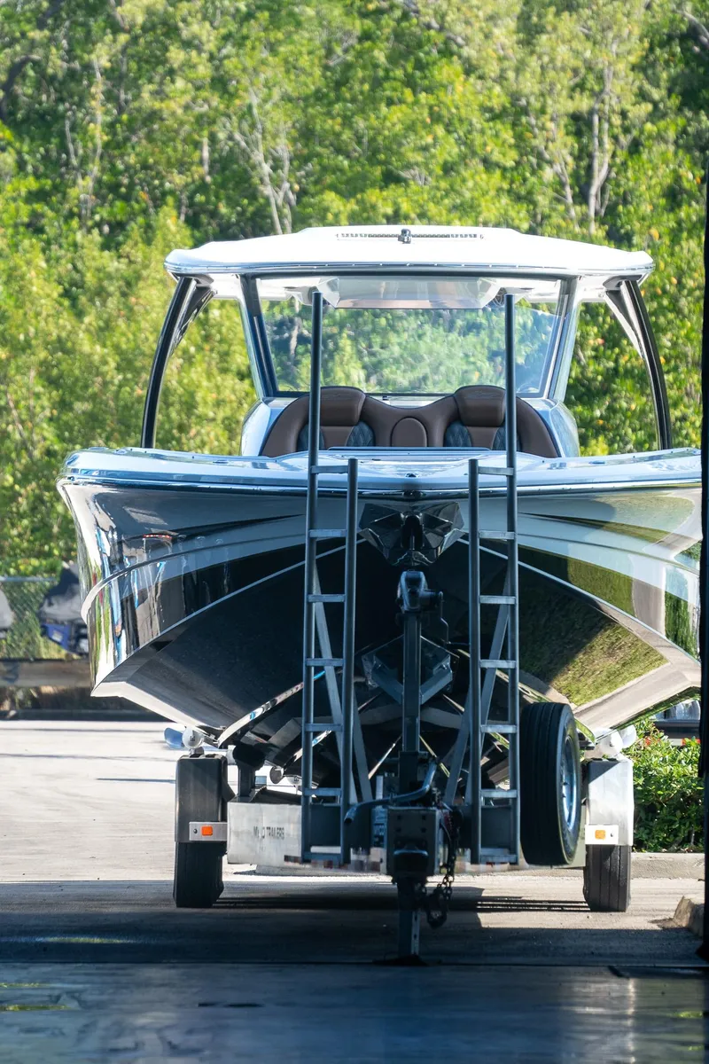 Slide: The Image of MTI V50 2022 boat on trailer, surrounded by lush greenery. - 2