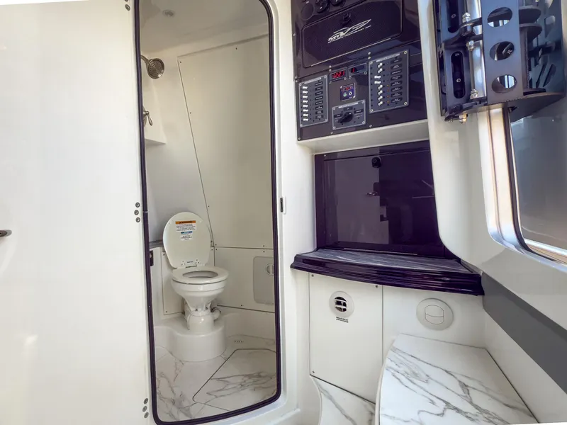 Slide: The Image of Interior of 2022 MTI V50 boat featuring a compact bathroom with modern amenities. - 21