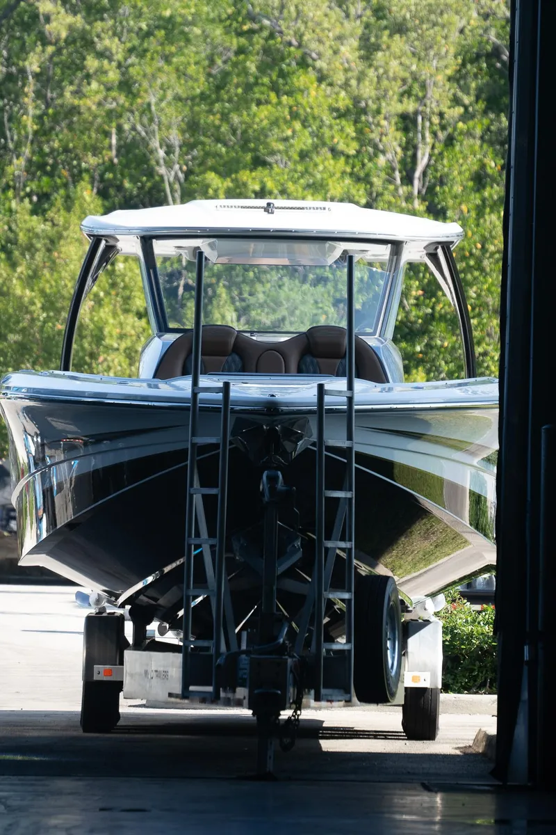 Slide: The Image of 2022 MTI V50 boat in storage, front view with lush greenery background. - 33