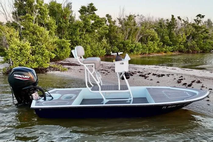 Slide: The Image of 2001 Pro Sports 16 boat with Mercury engine, docked near lush green shoreline. - 17