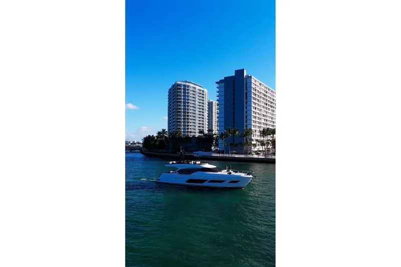 Slide: The Image of 2023 Ferretti Yachts 720 cruising near modern waterfront buildings. - 3