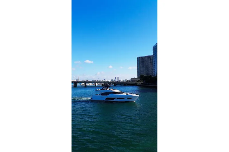 Slide: The Image of 2023 Ferretti Yachts 720 cruising on a sunny day near city skyline. - 2