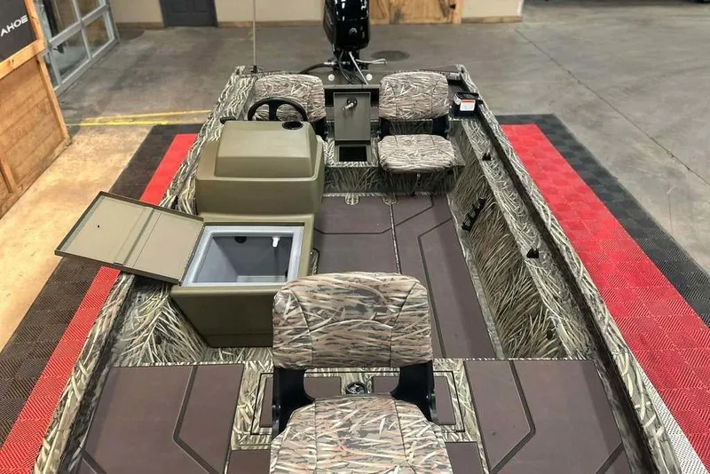 Slide: The Image of 2026 Tracker Grizzly 1754 SC boat interior with camo seats and storage compartments. - 13