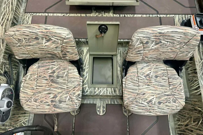 Slide: The Image of 2026 Tracker Grizzly 1754 SC boat interior with camo seats and center console. - 17