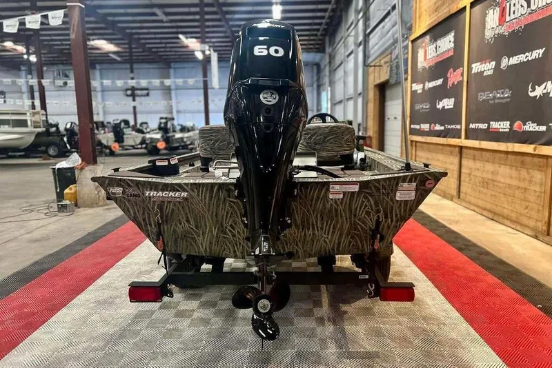 Slide: The Image of 2026 Tracker Grizzly 1754 SC boat with 60 HP engine in showroom. - 3