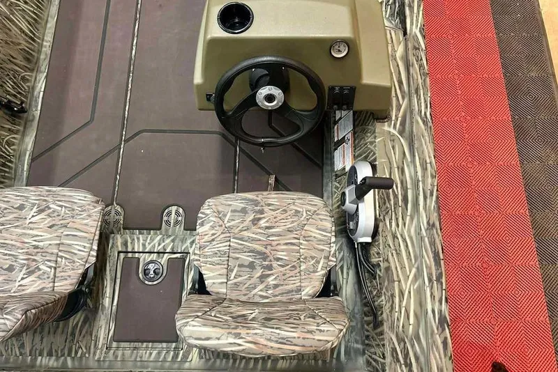 Slide: The Image of 2026 Tracker Grizzly 1754 SC boat interior with camouflage seats and steering console. - 7