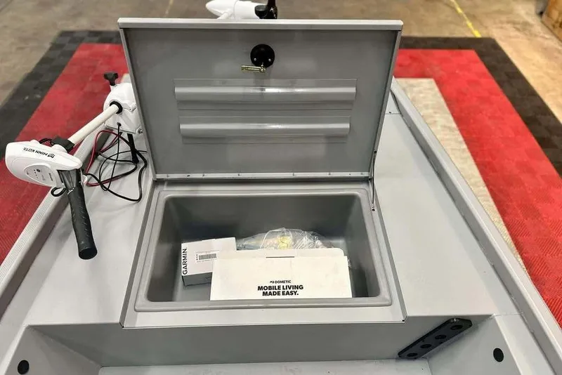 Slide: The Image of 2026 Tracker Bass Tracker Classic CC boat storage compartment with Garmin equipment and Minn Kota trolling motor. - 18