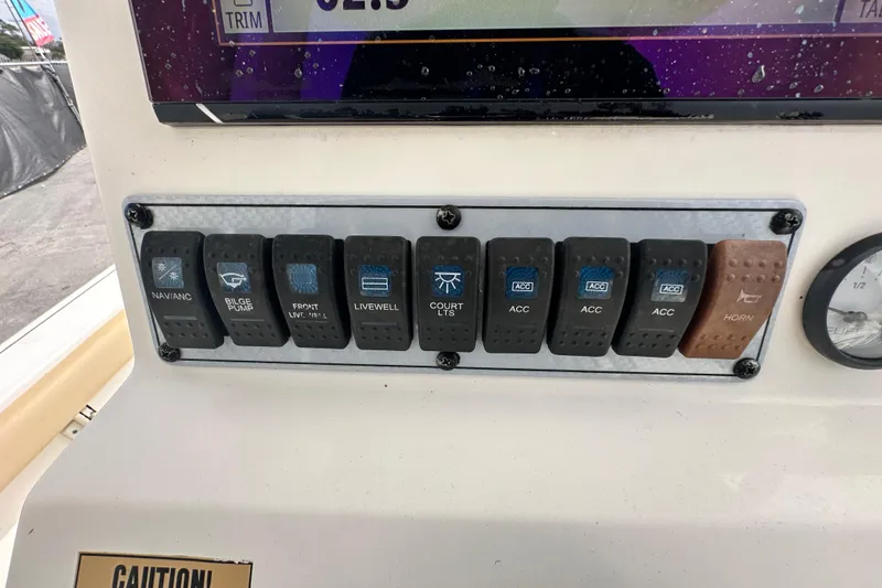 Slide: The Image of Control panel of a 2018 Key West 210 Bay Reef boat with labeled switches. - 21